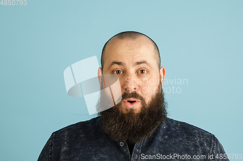 Image of Handsome caucasian man portrait isolated on blue studio background with copyspace