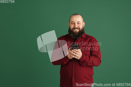 Image of Handsome caucasian man portrait isolated on green studio background with copyspace