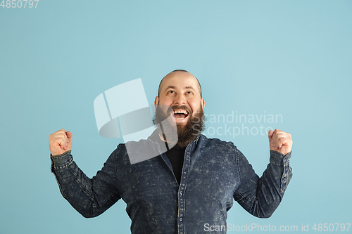 Image of Handsome caucasian man portrait isolated on blue studio background with copyspace