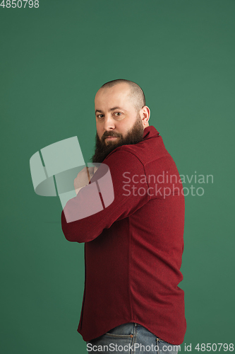 Image of Handsome caucasian man portrait isolated on green studio background with copyspace