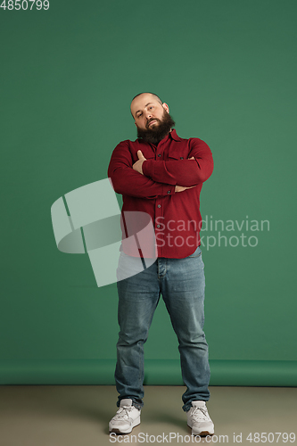 Image of Handsome caucasian man portrait isolated on green studio background with copyspace