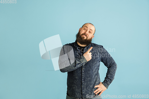 Image of Handsome caucasian man portrait isolated on blue studio background with copyspace