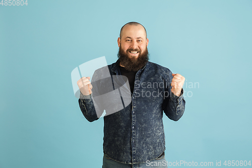 Image of Handsome caucasian man portrait isolated on blue studio background with copyspace