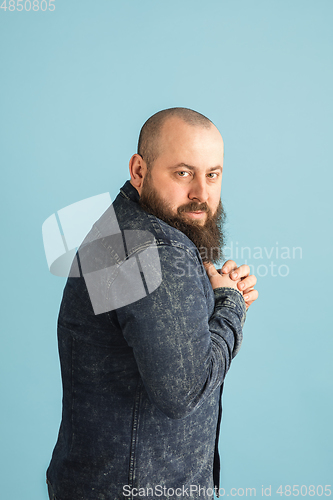 Image of Handsome caucasian man portrait isolated on blue studio background with copyspace