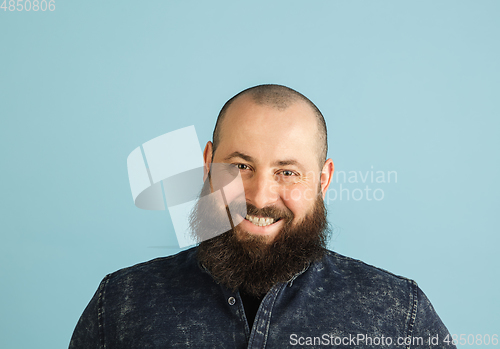 Image of Handsome caucasian man portrait isolated on blue studio background with copyspace