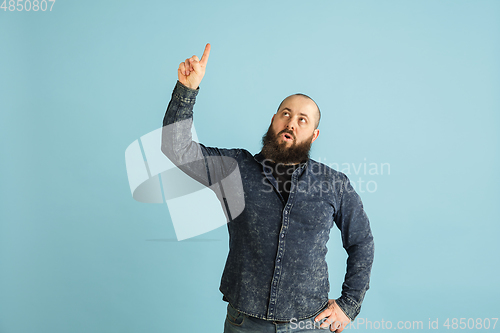 Image of Handsome caucasian man portrait isolated on blue studio background with copyspace