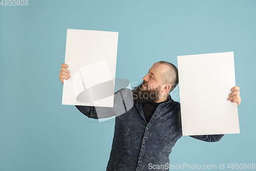 Image of Handsome caucasian man portrait isolated on blue studio background with copyspace