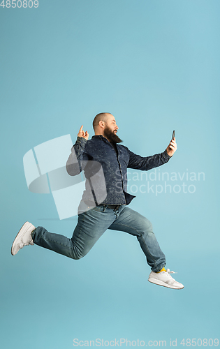 Image of Handsome caucasian man portrait isolated on blue studio background with copyspace
