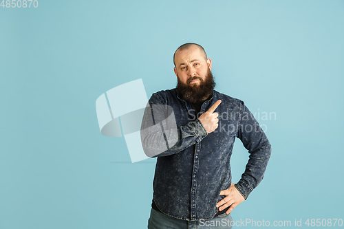 Image of Handsome caucasian man portrait isolated on blue studio background with copyspace