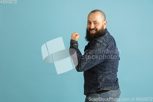 Image of Handsome caucasian man portrait isolated on blue studio background with copyspace