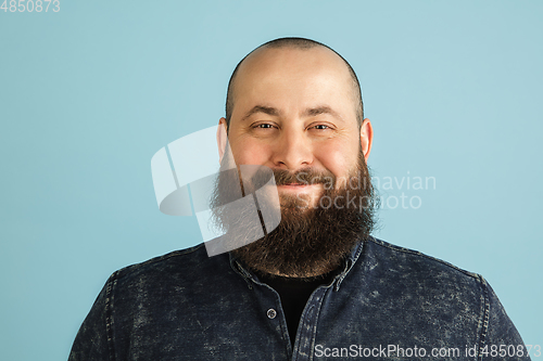 Image of Handsome caucasian man portrait isolated on blue studio background with copyspace