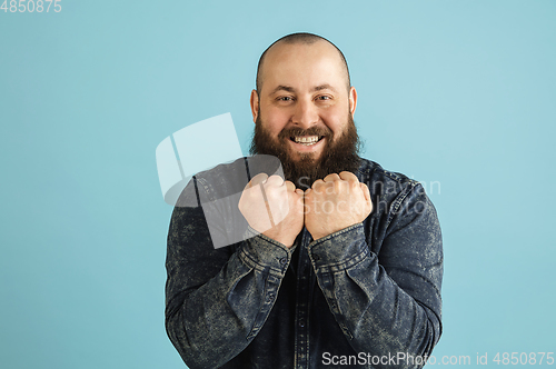 Image of Handsome caucasian man portrait isolated on blue studio background with copyspace