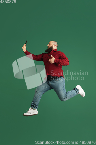 Image of Handsome caucasian man portrait isolated on green studio background with copyspace