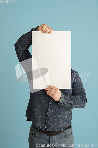 Image of Handsome caucasian man portrait isolated on blue studio background with copyspace