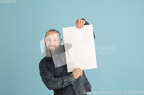 Image of Handsome caucasian man portrait isolated on blue studio background with copyspace