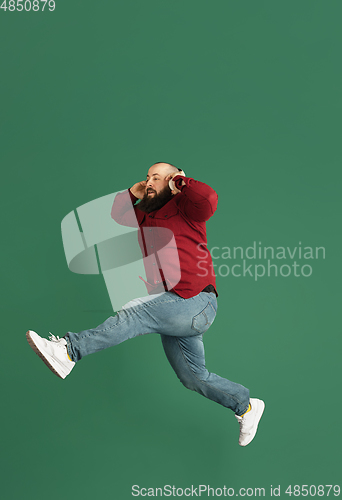 Image of Handsome caucasian man portrait isolated on green studio background with copyspace