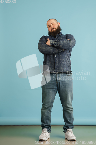 Image of Handsome caucasian man portrait isolated on blue studio background with copyspace