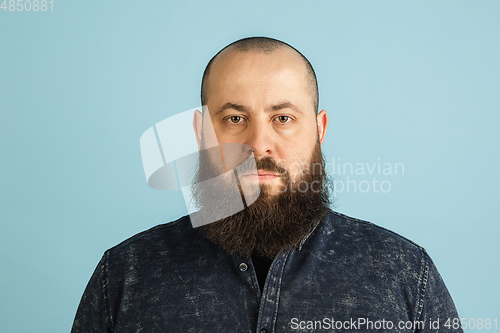 Image of Handsome caucasian man portrait isolated on blue studio background with copyspace