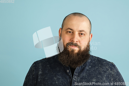 Image of Handsome caucasian man portrait isolated on blue studio background with copyspace