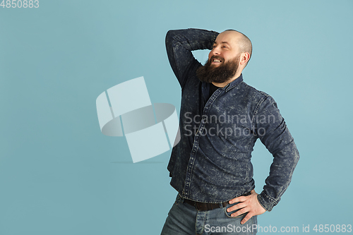 Image of Handsome caucasian man portrait isolated on blue studio background with copyspace