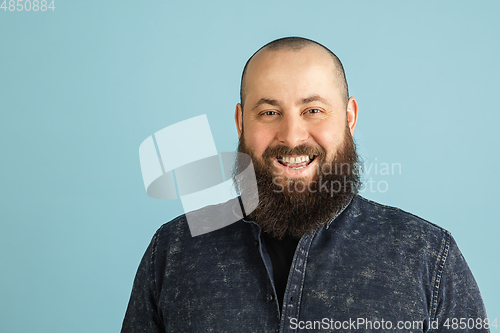 Image of Handsome caucasian man portrait isolated on blue studio background with copyspace