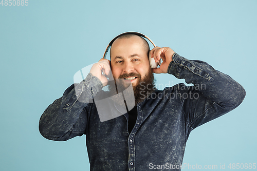 Image of Handsome caucasian man portrait isolated on blue studio background with copyspace