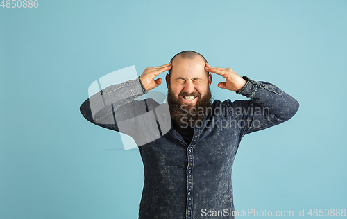 Image of Handsome caucasian man portrait isolated on blue studio background with copyspace