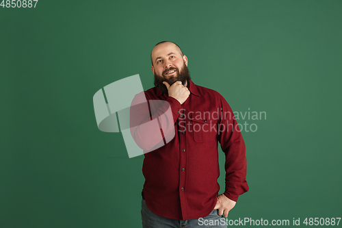 Image of Handsome caucasian man portrait isolated on green studio background with copyspace