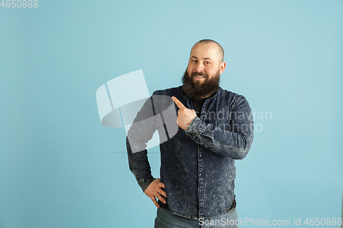 Image of Handsome caucasian man portrait isolated on blue studio background with copyspace