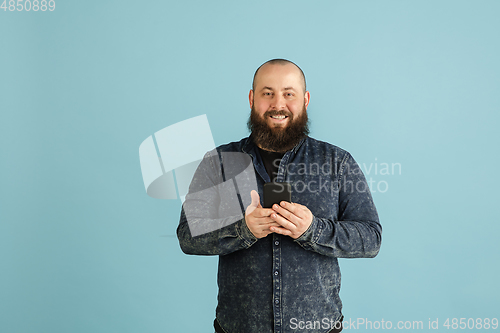 Image of Handsome caucasian man portrait isolated on blue studio background with copyspace