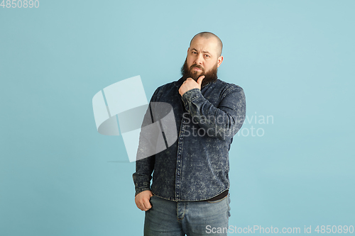 Image of Handsome caucasian man portrait isolated on blue studio background with copyspace