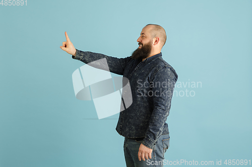 Image of Handsome caucasian man portrait isolated on blue studio background with copyspace