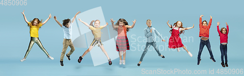 Image of Little and happy kids gesturing isolated on blue studio background. Human emotions, facial expression concept