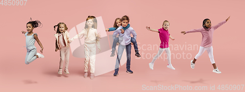 Image of Little and happy kids gesturing isolated on pink studio background. Human emotions, facial expression concept