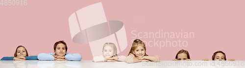 Image of Little and happy kids gesturing isolated on pink studio background. Human emotions, facial expression concept