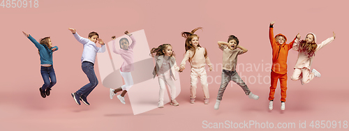 Image of Little and happy kids gesturing isolated on pink studio background. Human emotions, facial expression concept