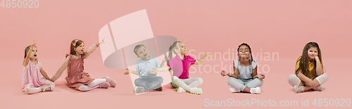 Image of Little and happy kids gesturing isolated on pink studio background. Human emotions, facial expression concept