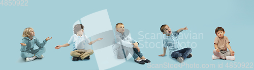 Image of Little and happy kids gesturing isolated on blue studio background. Human emotions, facial expression concept