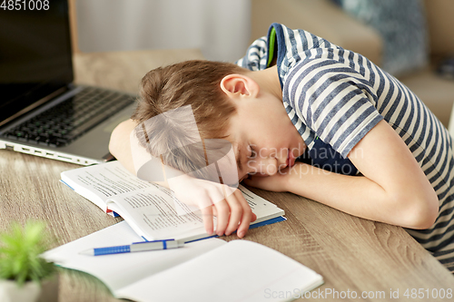 Image of tired student boy sleeping on desk at home