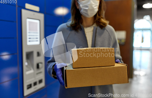 Image of woman in mask with boxes at parcel machine