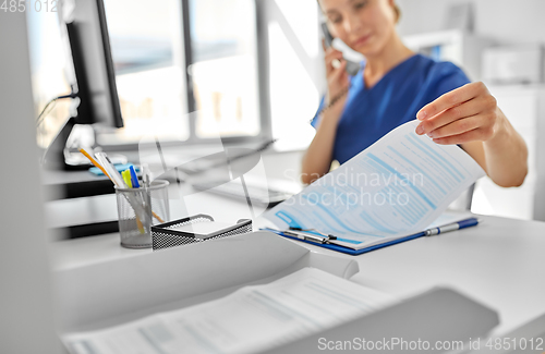 Image of doctor with computer calling on phone at hospital