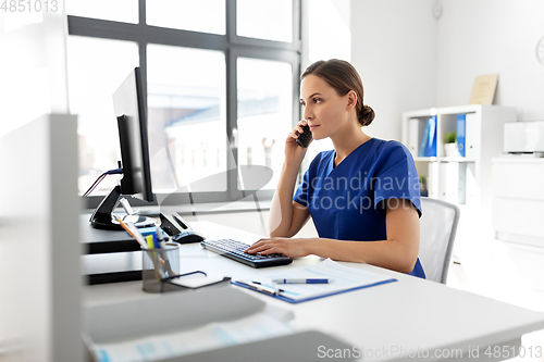 Image of doctor with computer calling on phone at hospital