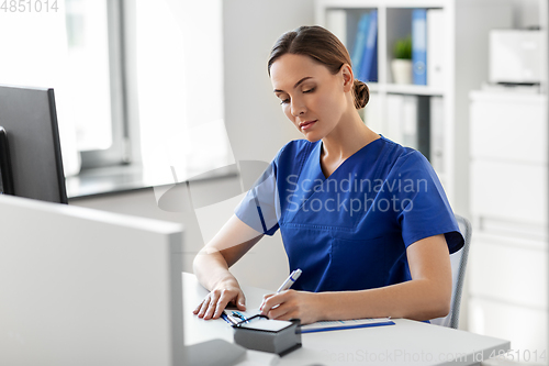 Image of doctor or nurse with clipboard working at hospital