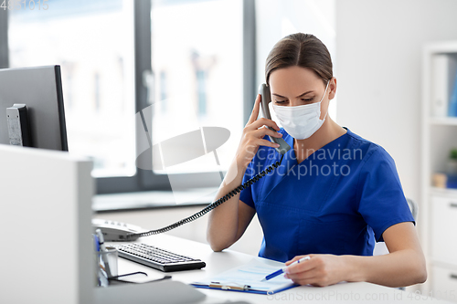 Image of doctor with computer calling on phone at hospital