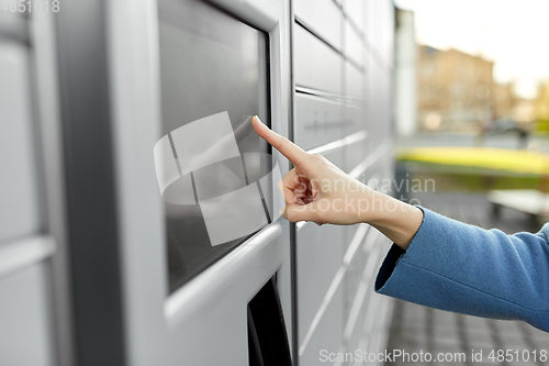 Image of close up of hand using automated parcel machine