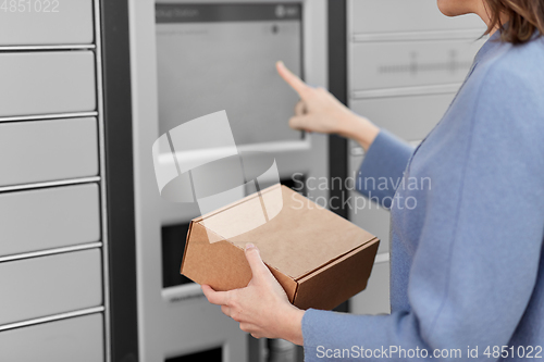 Image of smiling woman with box at automated parcel machine