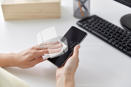 Image of close up of hands cleaning smartphone with tissue