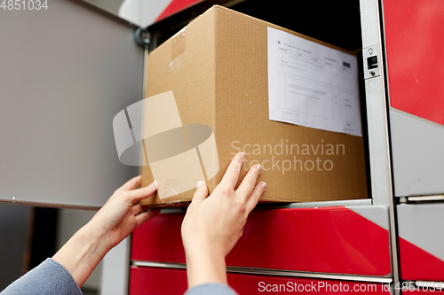 Image of woman putting box to automated parcel machine