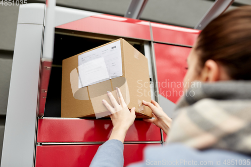 Image of woman putting box to automated parcel machine