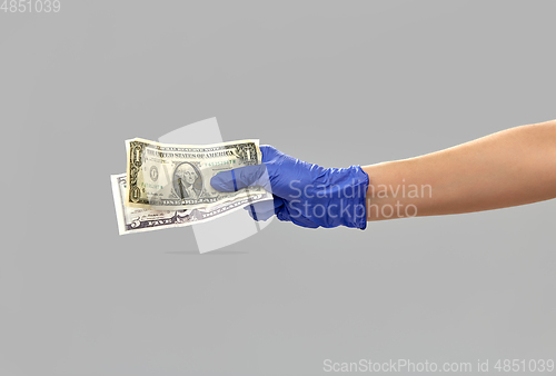 Image of close up of hand in medical glove with money